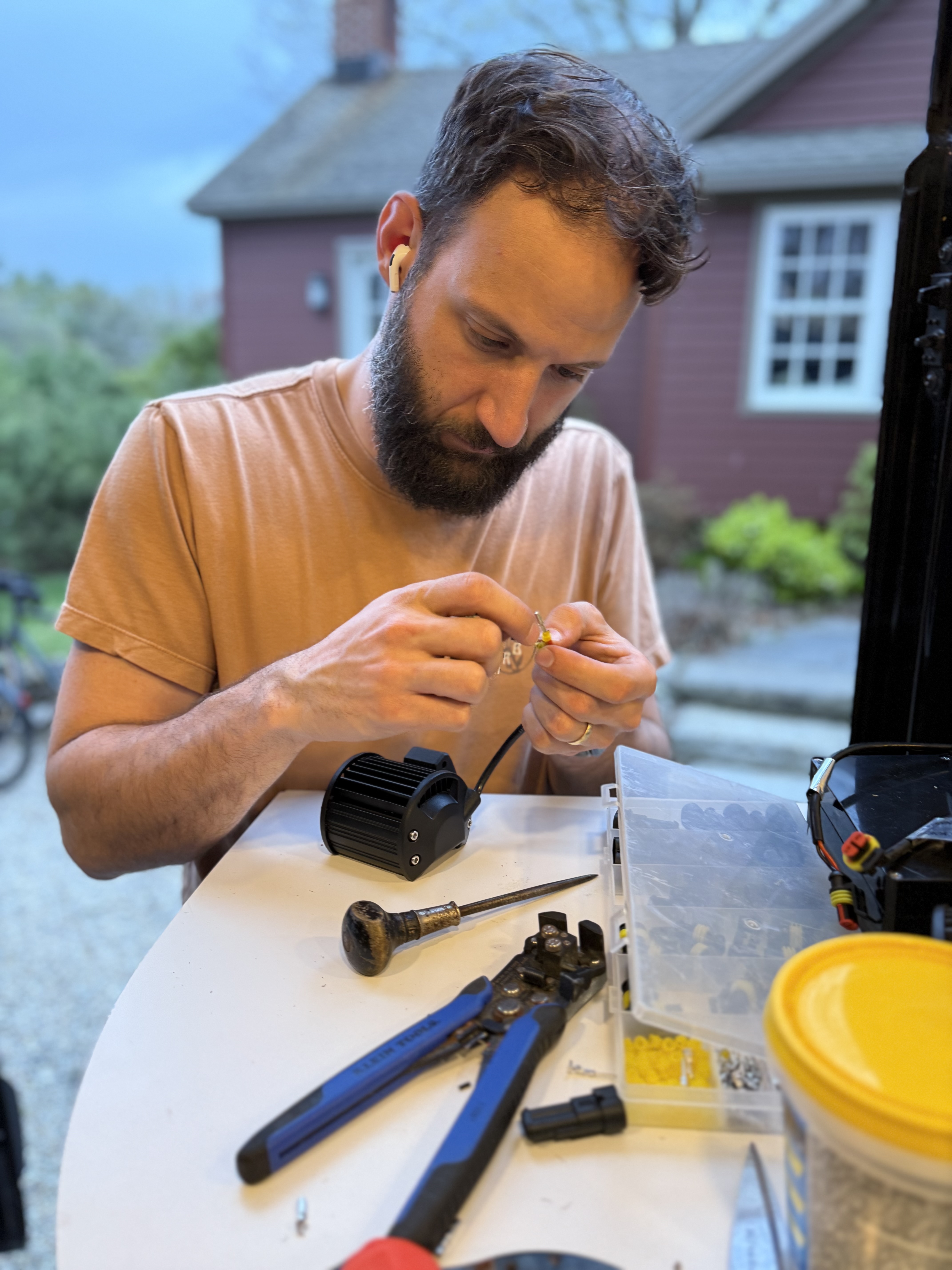 Mark working on a light’s wiring beside Benji during an earlier build session